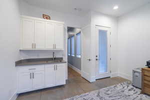 Kitchen with tile patterned flooring, sink, and white cabinets