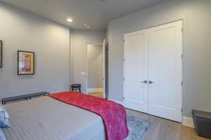 Bedroom with light hardwood / wood-style flooring and a closet