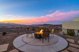 Patio terrace at dusk with a mountain view and a fire pit