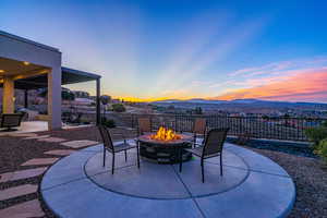 Patio terrace at dusk with a mountain view and a fire pit