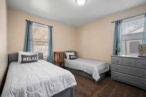 Bedroom featuring multiple windows and dark colored carpet