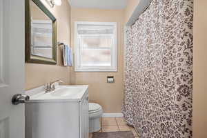 Bathroom with tile patterned flooring, vanity, and toilet