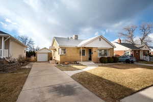 Bungalow-style home with an outbuilding, a garage, and a front yard