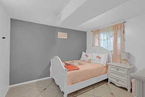 Bedroom with light tile patterned floors and a textured ceiling