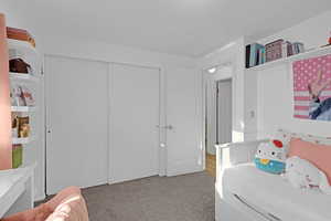 Bedroom featuring light colored carpet and a closet