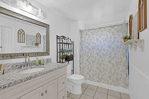 Bathroom with tile patterned flooring, vanity, a textured ceiling, toilet, and walk in shower