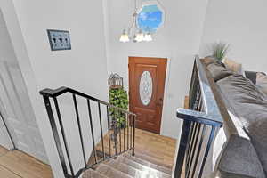 Foyer entrance with an inviting chandelier and hardwood / wood-style flooring