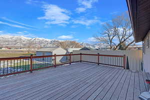 Wooden terrace featuring an outbuilding and a mountain view