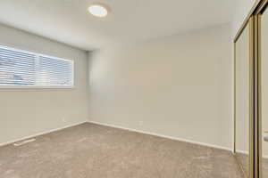 Unfurnished bedroom with light colored carpet and a closet