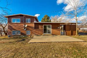 Rear view of house with a patio area and a lawn