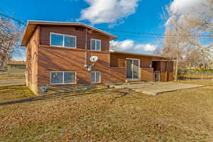 Rear view of property featuring a patio and a lawn