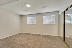 Empty room featuring a textured ceiling and carpet