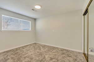 Unfurnished bedroom featuring carpet and a closet