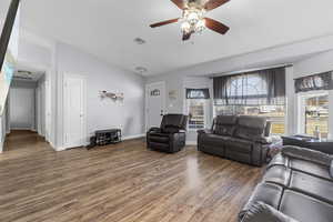 Living room with lofted ceiling, hardwood / wood-style flooring, and ceiling fan