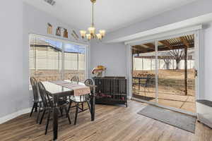 Dining area featuring hardwood / wood-style floors and a notable chandelier