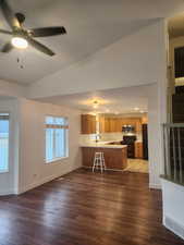 Vaulted ceiling, sink, light hardwood / wood-style floors, and ceiling fan