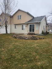 Back of house featuring a patio area, central air condition unit, and a lawn