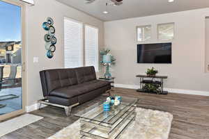 Living room featuring dark wood-type flooring and ceiling fan