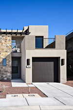 View of front of house featuring a garage and a balcony