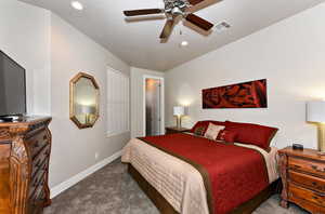 Bedroom featuring dark carpet and ceiling fan