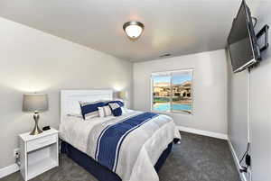 Bedroom featuring dark colored carpet