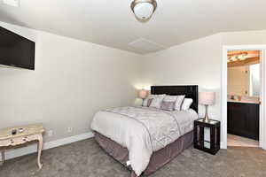 Bedroom featuring light colored carpet and connected bathroom