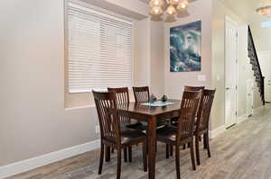 Dining space with hardwood / wood-style flooring and a chandelier