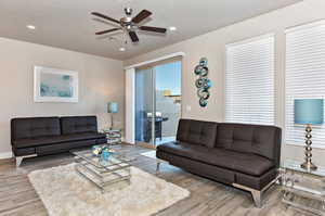 Living room featuring ceiling fan and wood-type flooring