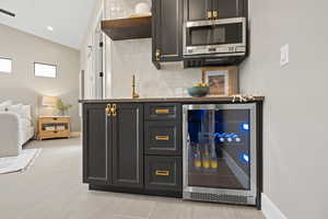 Bar featuring tasteful backsplash and beverage cooler