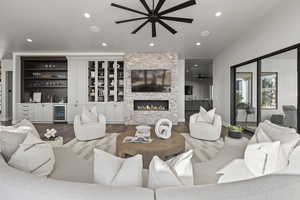 Living room featuring lofted ceiling, ceiling fan, wine cooler, wood-type flooring, and indoor bar