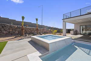 View of swimming pool featuring a patio area and an in ground hot tub