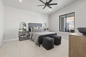 Carpeted bedroom featuring ceiling fan and lofted ceiling