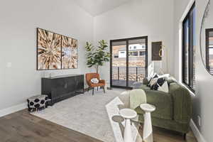 Living room with hardwood / wood-style flooring and a towering ceiling