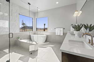 Bathroom featuring vanity, shower with separate bathtub, tile patterned flooring, and tile walls