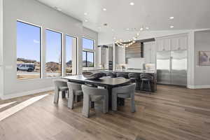 Dining room with a mountain view, decorative columns, a high ceiling, and light wood-type flooring