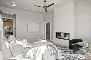 Bedroom featuring ceiling fan, wood-type flooring, and a fireplace