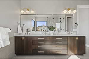 Bathroom featuring tile patterned floors, vanity, and a shower with shower door