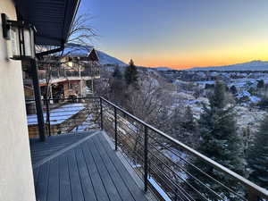 Snow covered back of property with a mountain view