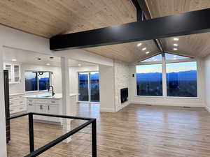 Living room with a mountain view, sink, wooden ceiling, and a fireplace