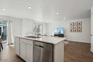 Kitchen featuring sink, white cabinetry, stainless steel dishwasher, dark hardwood / wood-style floors, and a kitchen island with sink