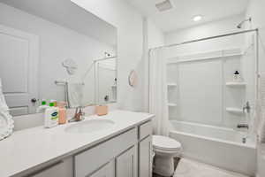 Full bathroom with vanity, shower / tub combo, and toilet