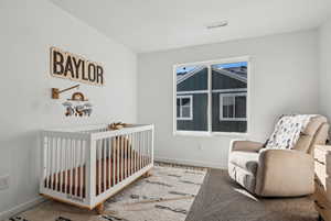 Bedroom featuring a crib and carpet flooring