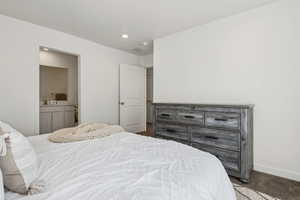 Carpeted bedroom featuring connected bathroom and sink