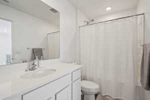 Full bathroom with vanity, toilet, and shower / bathtub combination with curtain