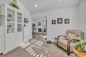 Living area with lofted ceiling and carpet flooring