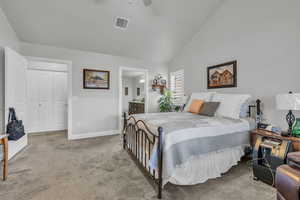 Bedroom with vaulted ceiling, connected bathroom, carpet flooring, ceiling fan, and a closet