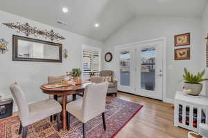 Dining room featuring lofted ceiling and light wood-type flooring