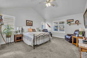 Carpeted bedroom featuring lofted ceiling and ceiling fan