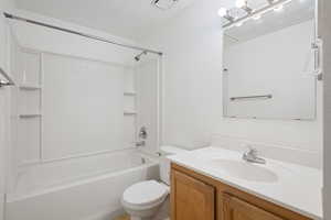 Full bathroom with vanity,  shower combination, and toilet