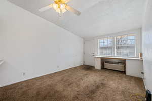 Unfurnished bedroom featuring ceiling fan, an AC wall unit, a textured ceiling, and carpet